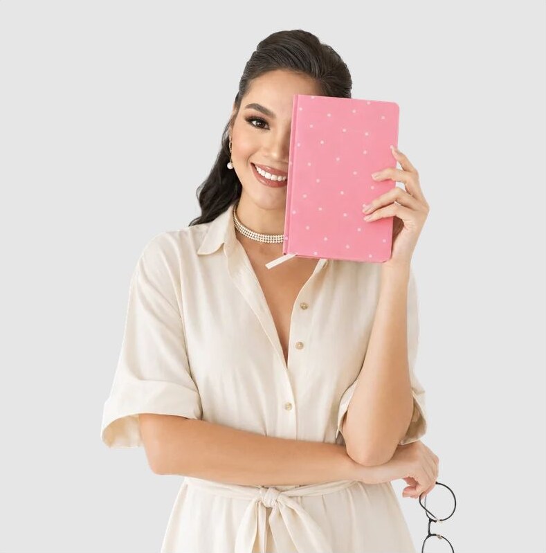 Lanie smiling and holding a pink planner